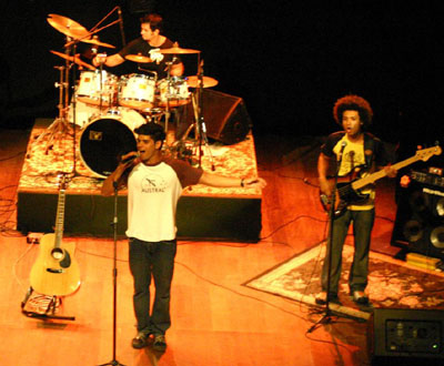 Banda Neles no palco: Da esquerda para a direita: Eduardo Manu (bateria), Thaizinho (baixo) e Pedro Viccteri (vocais)